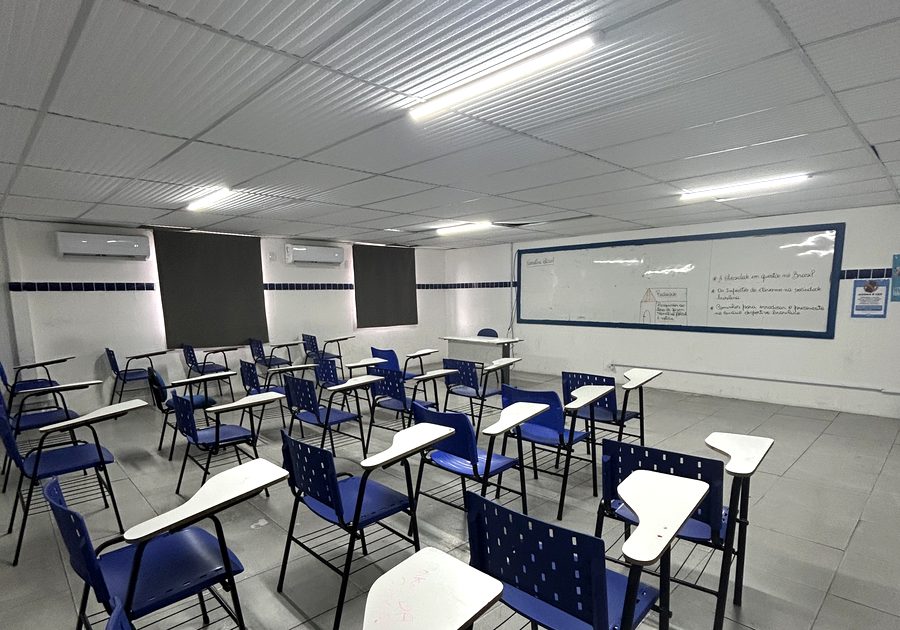 Sala de aula do Colégio Anglo Lauro, com carteiras universitárias e lousa branca